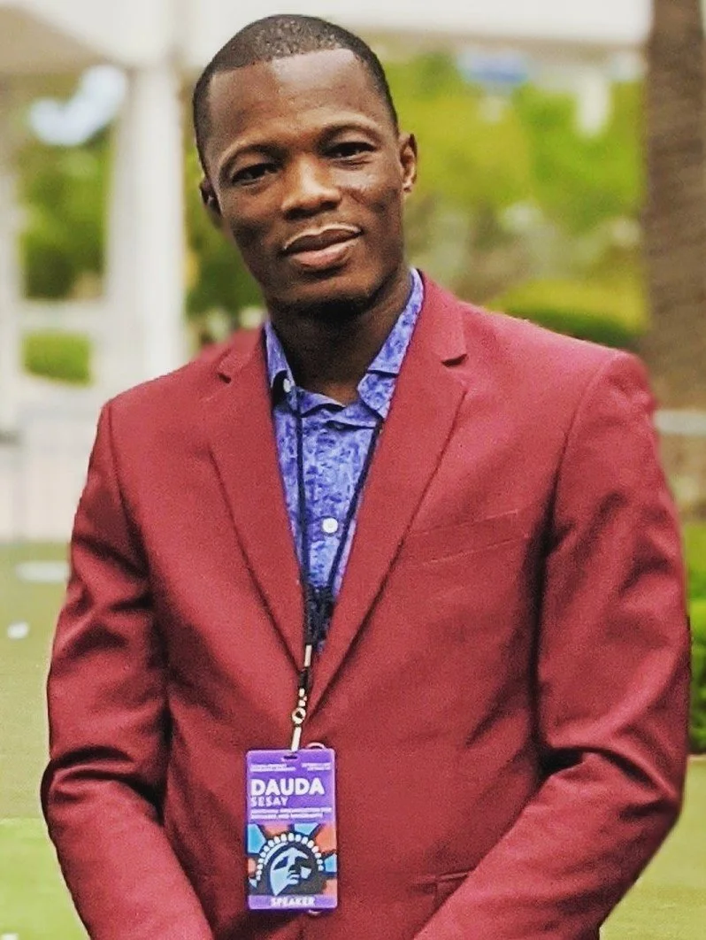 Dauda Sesay wearing a red blazer.